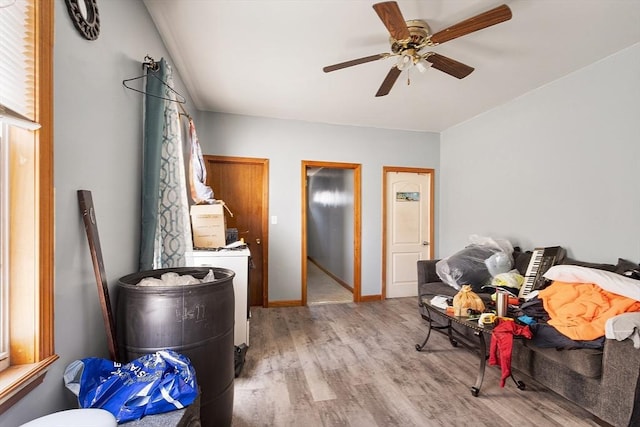 interior space with baseboards, a ceiling fan, and light wood-style flooring