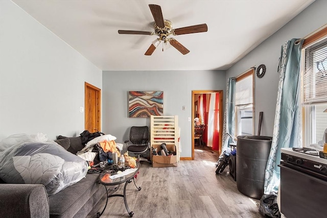 living area with light wood-type flooring and a ceiling fan