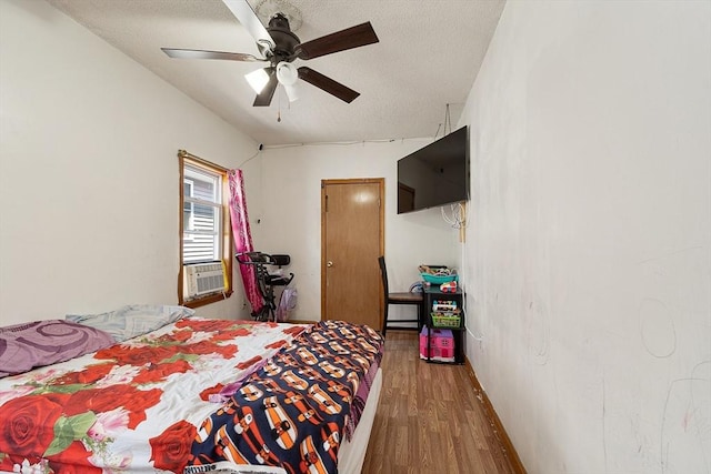 bedroom featuring wood finished floors, ceiling fan, and a textured ceiling