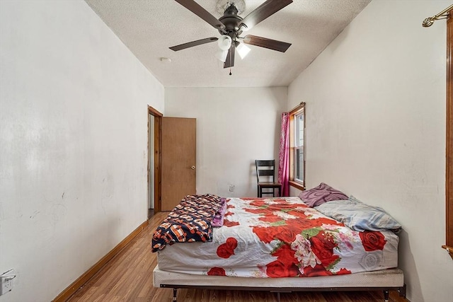 bedroom featuring a textured ceiling, ceiling fan, and light wood-type flooring