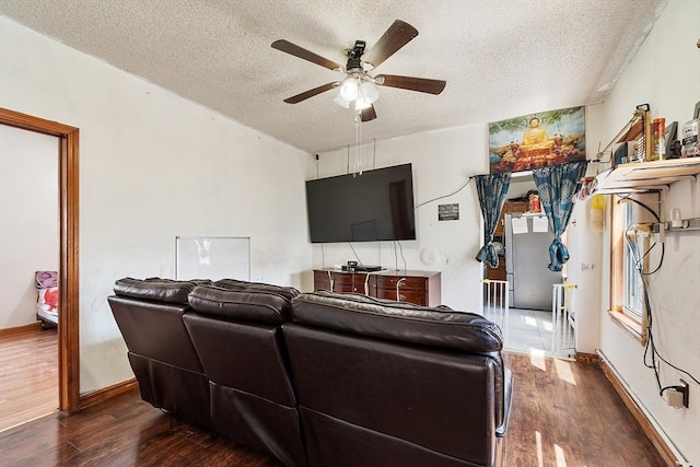 living area featuring a textured ceiling, ceiling fan, wood finished floors, and baseboards