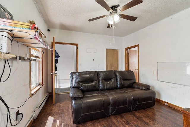 living room with a textured ceiling, ceiling fan, a baseboard heating unit, baseboards, and wood finished floors