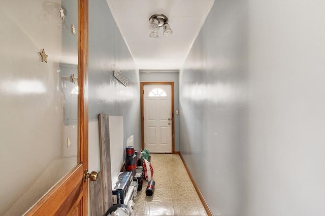 doorway to outside with baseboards and light floors