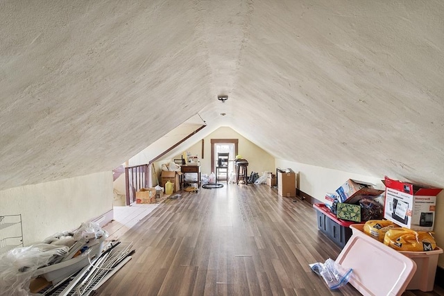 additional living space with vaulted ceiling and wood finished floors