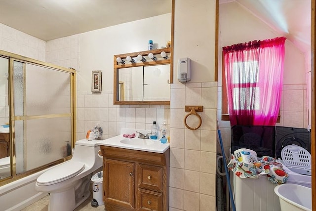 full bathroom featuring toilet, tile walls, bath / shower combo with glass door, and vanity