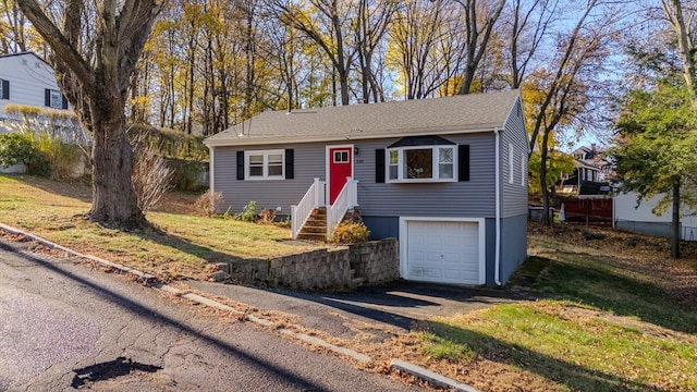 single story home featuring a garage and a front lawn