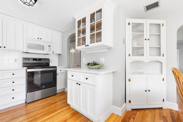 273 Greendale Ave, Needham, MA 02494 - kitchen with stainless steel electric range oven, arched walkways, white microwave, light wood-type flooring, and light countertops