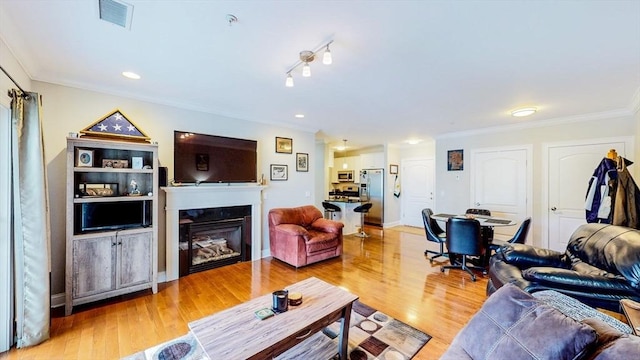 1100 Vfw Pkwy Unit 202, Boston, MA 02132 - living room with crown molding, light wood-style floors, a glass covered fireplace, and recessed lighting