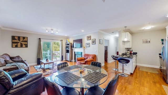 1100 Vfw Pkwy Unit 202, Boston, MA 02132 - dining room with crown molding, light wood finished floors, baseboards, and a glass covered fireplace