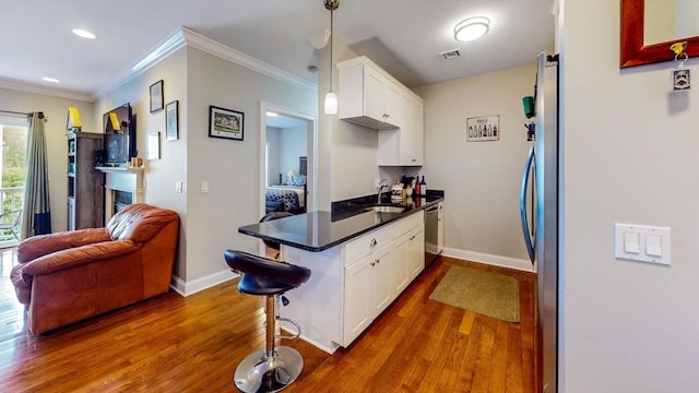 1100 Vfw Pkwy Unit 202, Boston, MA 02132 - kitchen featuring white cabinetry, appliances with stainless steel finishes, dark wood finished floors, baseboards, and ornamental molding