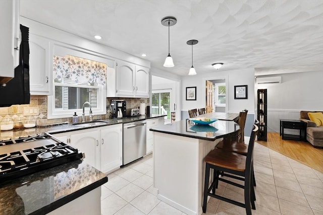 kitchen with an AC wall unit, a sink, light tile patterned floors, and dishwasher