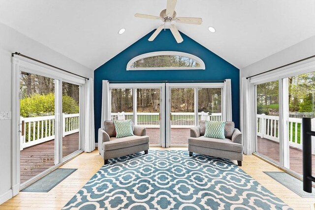 sunroom with plenty of natural light, a ceiling fan, and a wooden deck