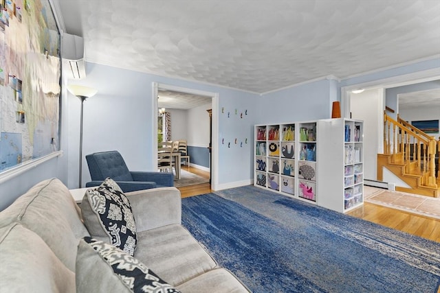 living room with stairway, baseboards, a baseboard radiator, and wood finished floors