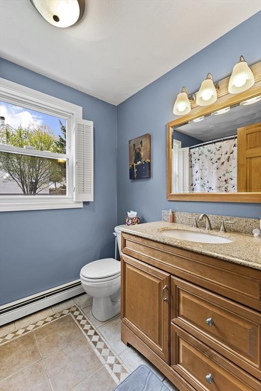full bath featuring toilet, tile patterned floors, a baseboard heating unit, and vanity