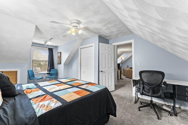 carpeted bedroom featuring a closet, ceiling fan, vaulted ceiling, and a textured ceiling