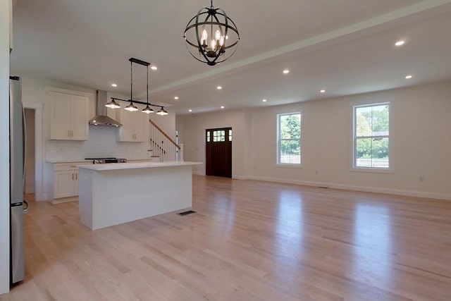 12 Willow St, Pepperell, MA 01463 - kitchen featuring wall chimney range hood, freestanding refrigerator, white cabinets, light wood-style flooring, and recessed lighting