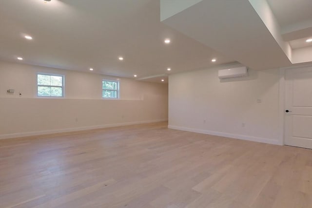 12 Willow St, Pepperell, MA 01463 - basement with a wall unit AC, light wood-style floors, recessed lighting, and baseboards