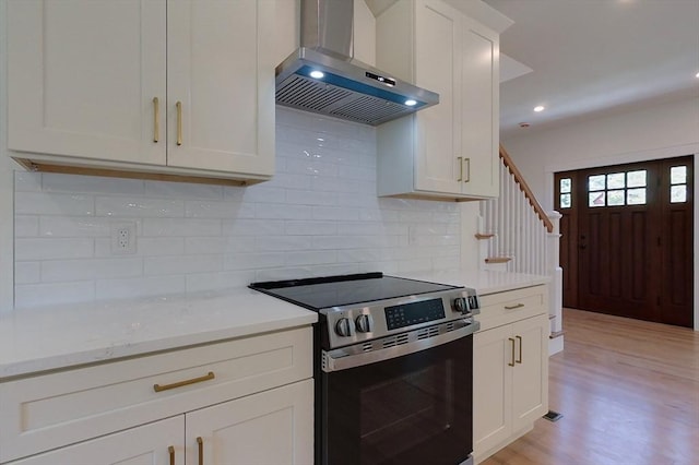 12 Willow St, Pepperell, MA 01463 - kitchen with wall chimney exhaust hood, stainless steel electric range, light wood finished floors, tasteful backsplash, and recessed lighting