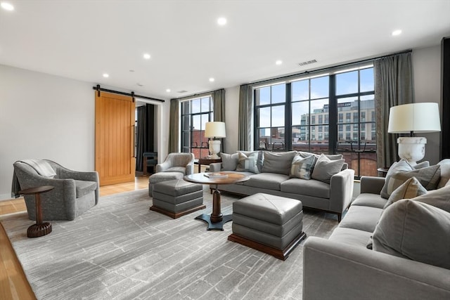 living area featuring recessed lighting, a city view, light wood finished floors, and a barn door