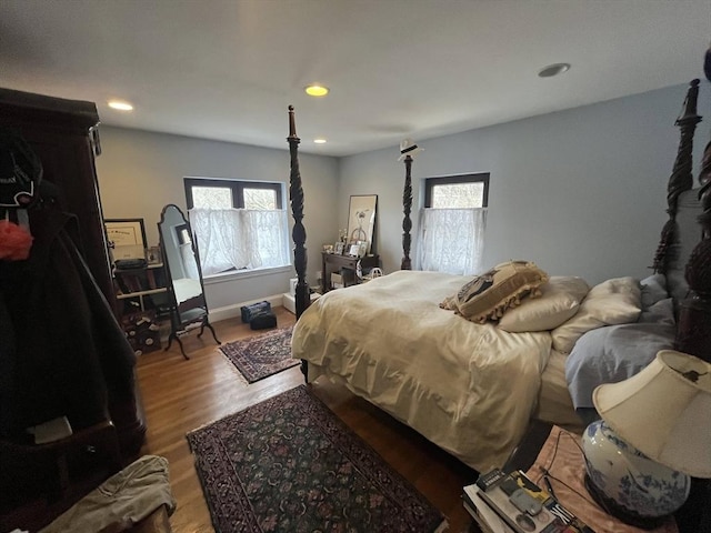 bedroom featuring wood finished floors, recessed lighting, and baseboards