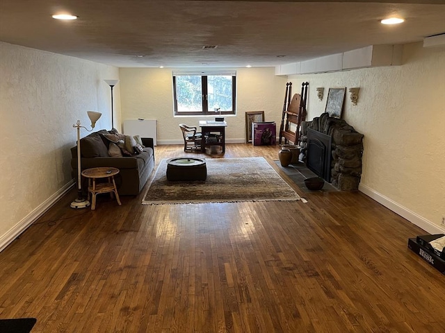 living area with a textured wall, hardwood / wood-style flooring, baseboards, and recessed lighting