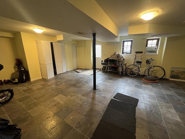 below grade area with stone tile flooring and baseboards