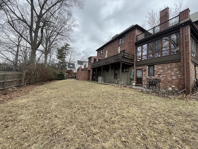 back of house featuring brick siding and a chimney