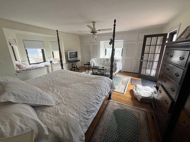 bedroom featuring wood finished floors, multiple windows, and a ceiling fan