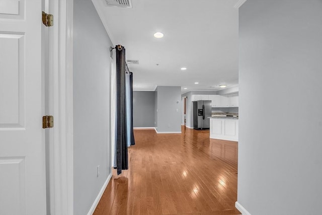 hall with ornamental molding and hardwood / wood-style flooring