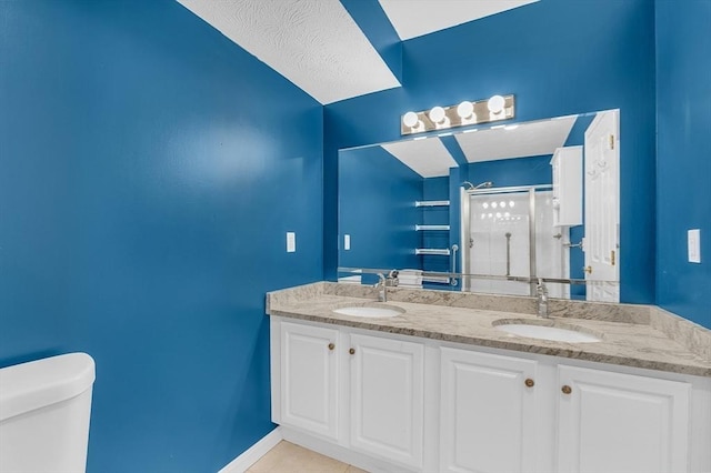 bathroom with tile patterned floors, a shower with door, vanity, and toilet