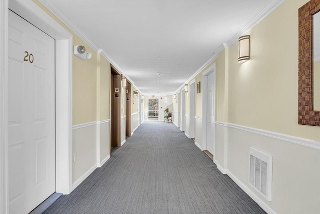 hallway featuring crown molding and dark carpet