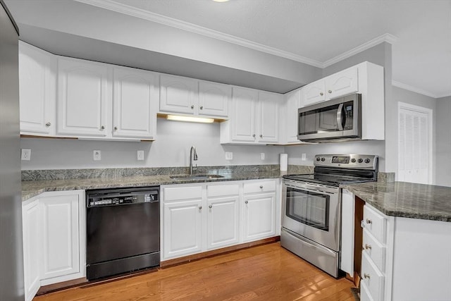 kitchen featuring appliances with stainless steel finishes, light hardwood / wood-style flooring, white cabinetry, and sink