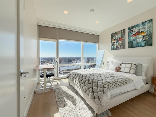 bedroom featuring wood finished floors, recessed lighting, and baseboards