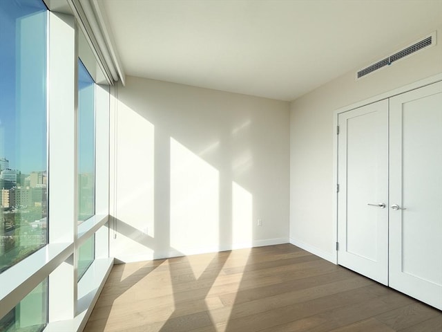spare room featuring dark wood finished floors and baseboards