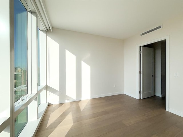 unfurnished room featuring dark wood-style flooring and baseboards