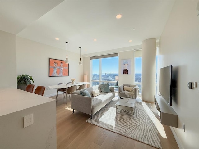 living area with light wood-type flooring and recessed lighting