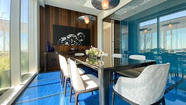 dining room with wood walls and marble finish flooring