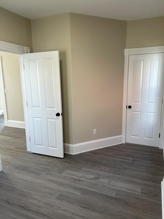 unfurnished bedroom featuring dark wood-style floors and baseboards