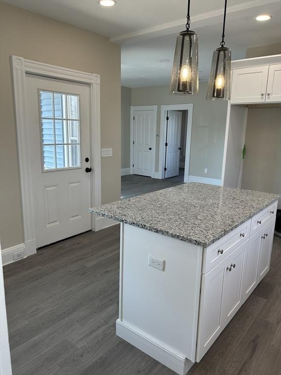 kitchen with dark wood finished floors, decorative light fixtures, light stone counters, and white cabinetry