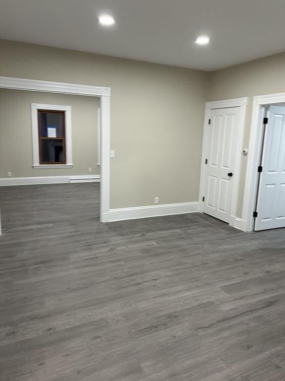 spare room featuring dark wood finished floors, recessed lighting, and baseboards