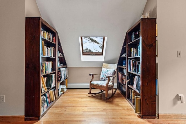525 Thurston St, Wrentham, MA 02093 - living area with wood finished floors, a skylight, wall of books, and vaulted ceiling