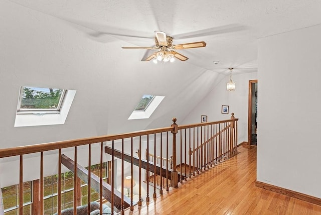 525 Thurston St, Wrentham, MA 02093 - hallway featuring a skylight, light wood-style floors, an upstairs landing, vaulted ceiling, and baseboards