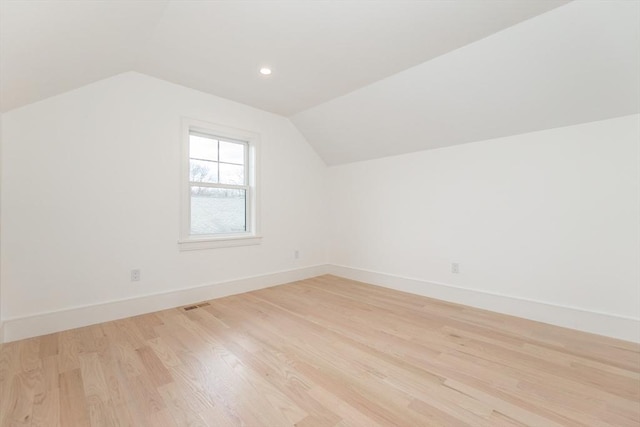 additional living space with light wood finished floors, lofted ceiling, recessed lighting, visible vents, and baseboards