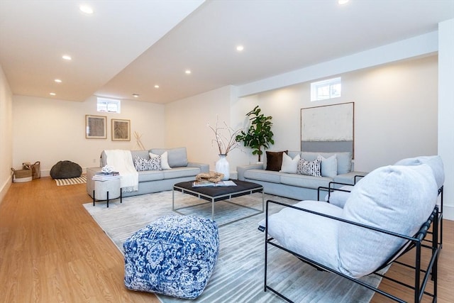 living area with baseboards, wood finished floors, and recessed lighting