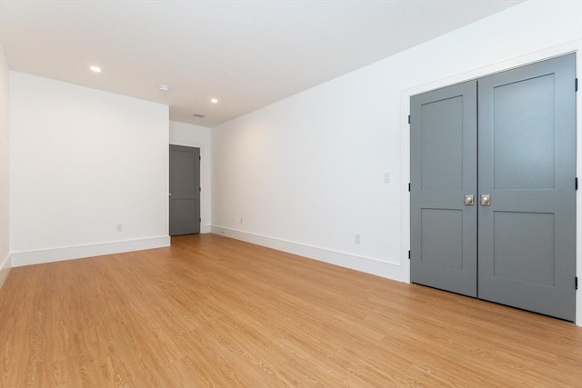 spare room featuring recessed lighting, light wood-style flooring, and baseboards