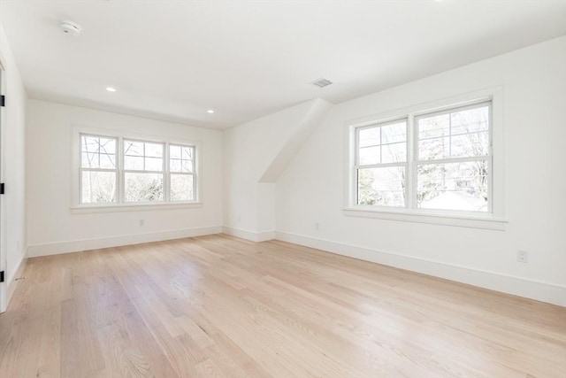 interior space featuring light wood finished floors, plenty of natural light, visible vents, and baseboards