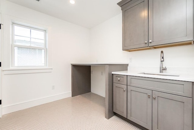 interior space with baseboards, a sink, and recessed lighting