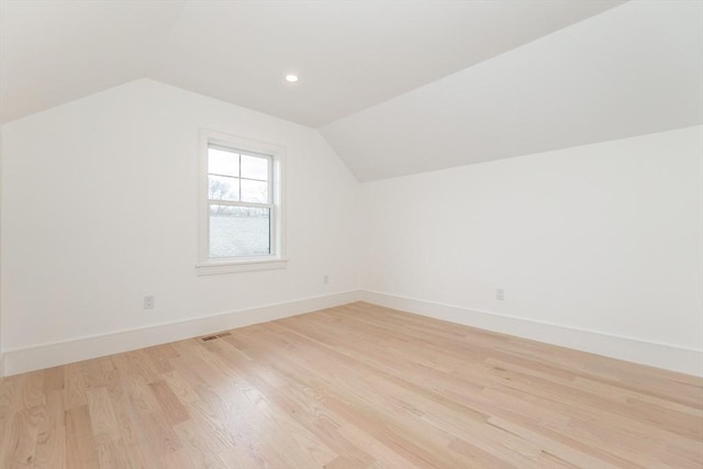 additional living space with lofted ceiling, recessed lighting, visible vents, baseboards, and light wood-style floors