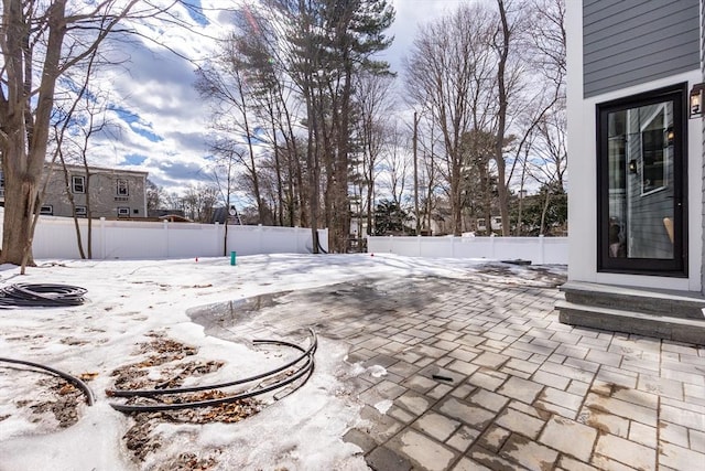 snow covered patio featuring entry steps and a fenced backyard