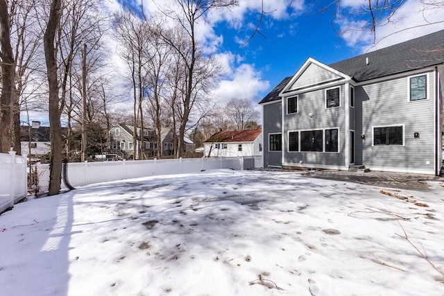 snow covered back of property with fence private yard